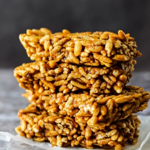 four square slices of homemade rice crispy treats stacked on top of each other