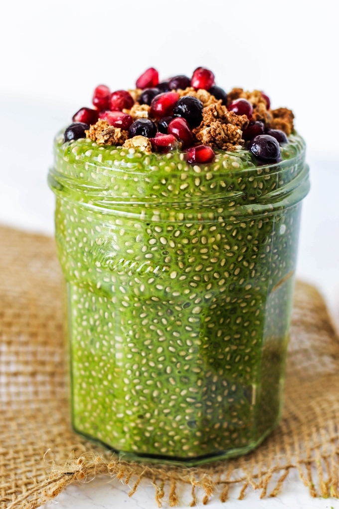 a jar of chia pudding flavored with matcha tea and topped with granola and fruit