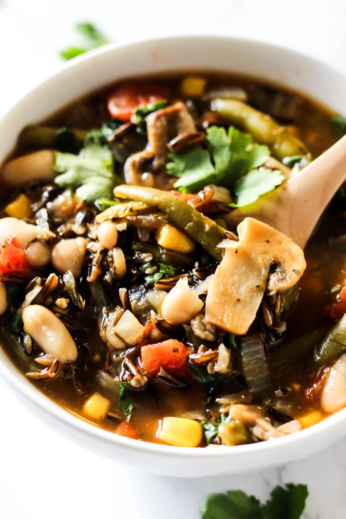 a spoon digging into a bowl of wild rice soup