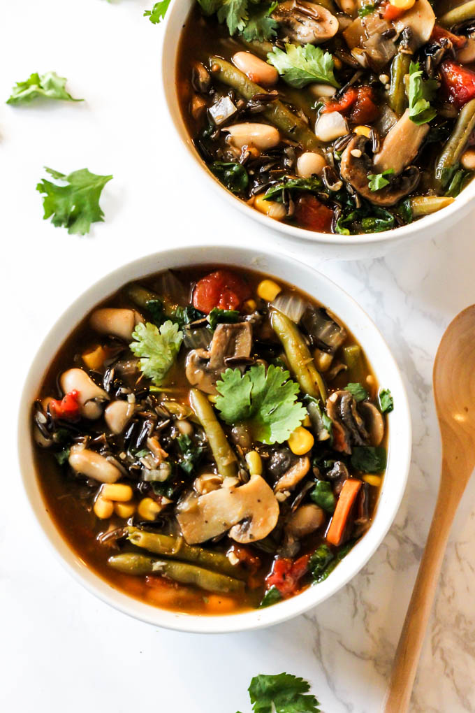 two bowls of wild rice soup filled with vegetables