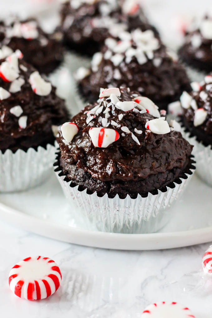 a plate of chocolate peppermint cupcakes topped with peppermints