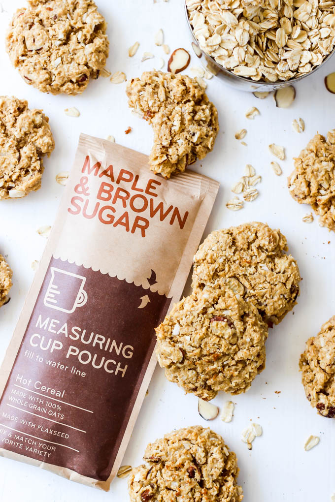 a batch of coconut almond oatmeal cookies surrounding a pack of maple brown sugar instant oatmeal