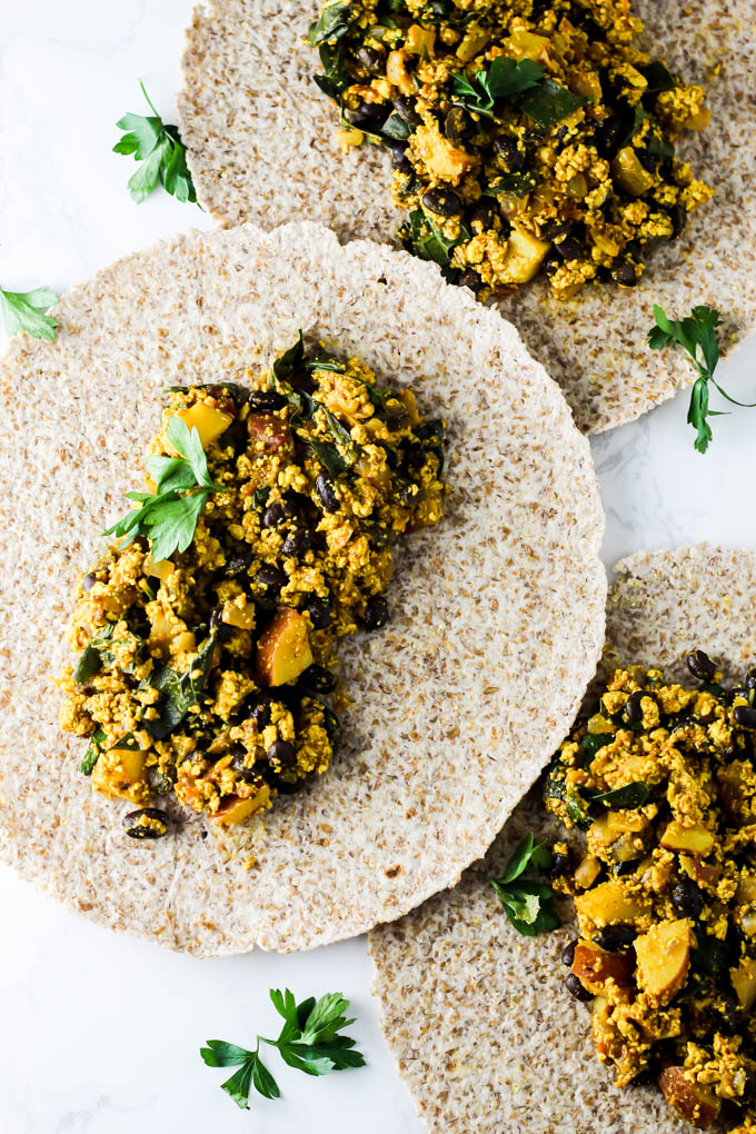 three tortillas with a tofu scramble filling scooped on each one