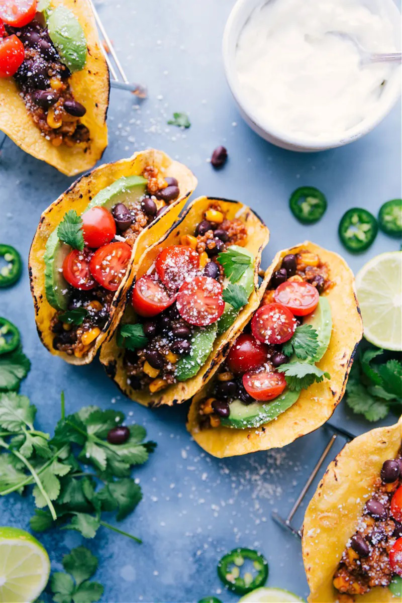 three quinoa stuffed tacos topped with tomatoes