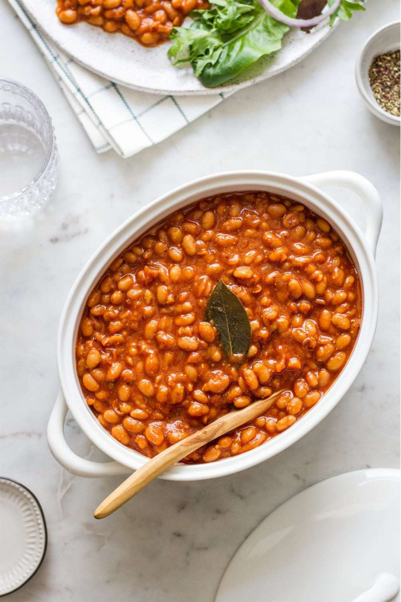 a large serving dish filled with baked beans