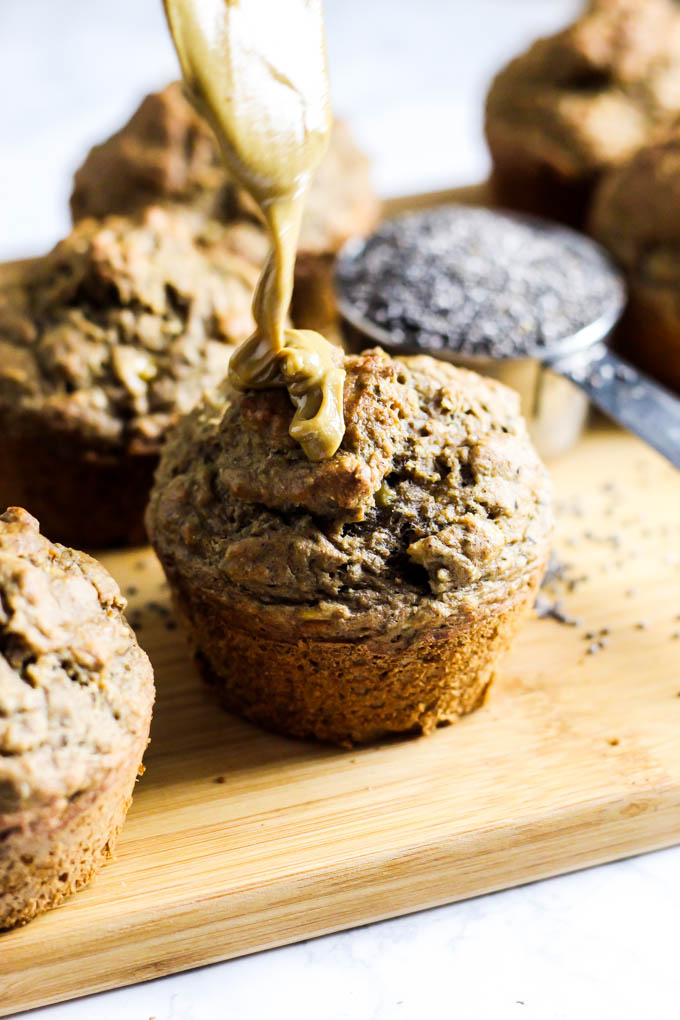 almond butter being drizzled onto a banana muffin