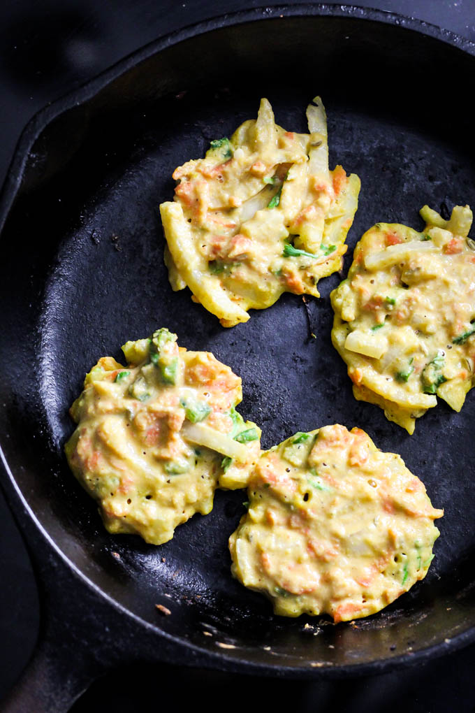 Add these Crispy Onion & Carrot Fritters to dinner for a flavorful, vegetable-packed side dish! A dollop of cumin yogurt tops it off. Vegan & gluten-free!