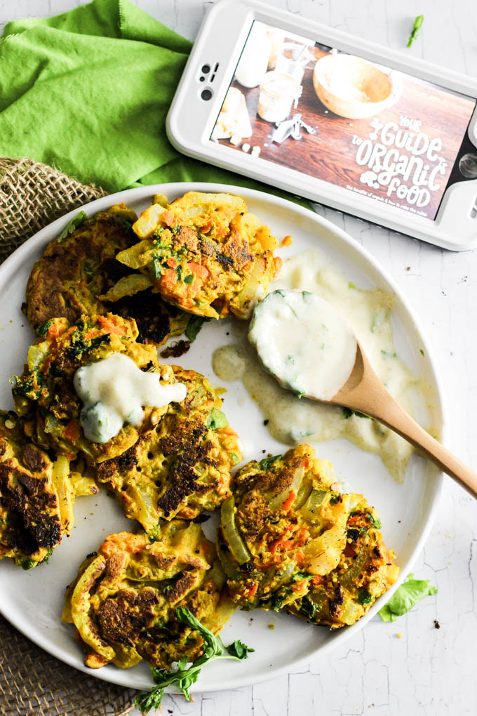 Add these Crispy Onion & Carrot Fritters to dinner for a flavorful, vegetable-packed side dish! A dollop of cumin yogurt tops it off. Vegan & gluten-free!
