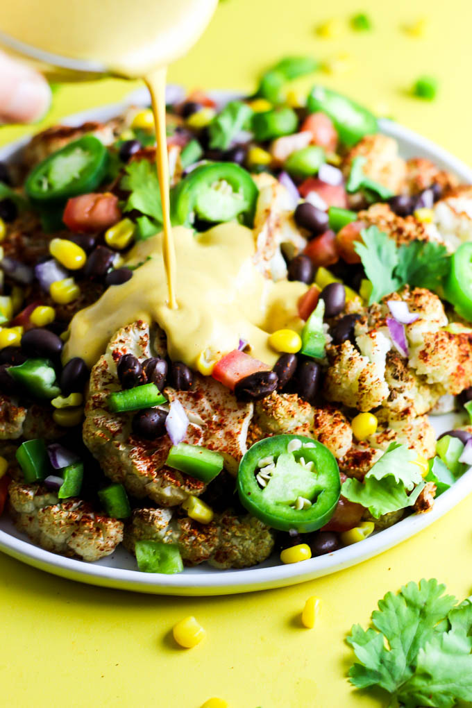 Not only are these vegan Loaded Cauliflower Nachos great for a party, but they're simple enough for a weeknight meal! Don't forget the creamy cashew queso.