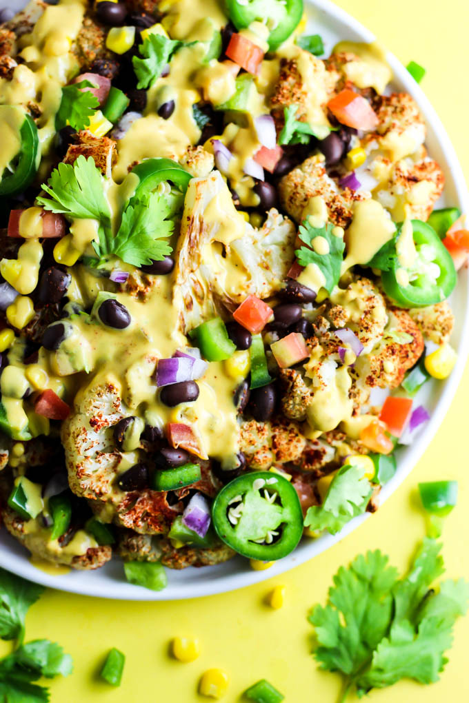 Not only are these vegan Loaded Cauliflower Nachos great for a party, but they're simple enough for a weeknight meal! Don't forget the creamy cashew queso.