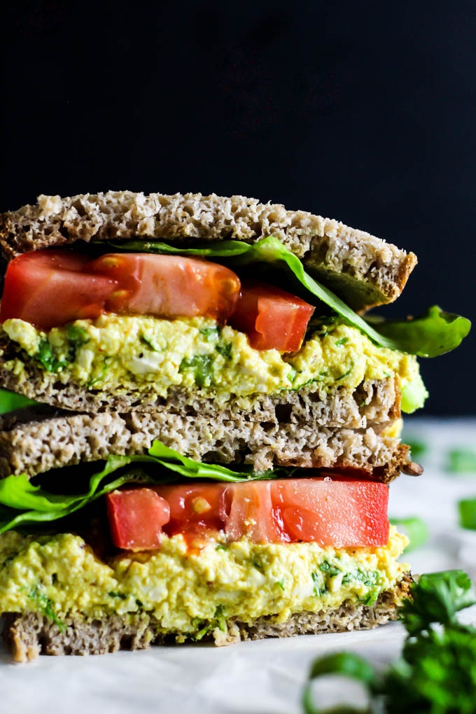 Two halves of a tofu salad sandwich stacked on top of one another