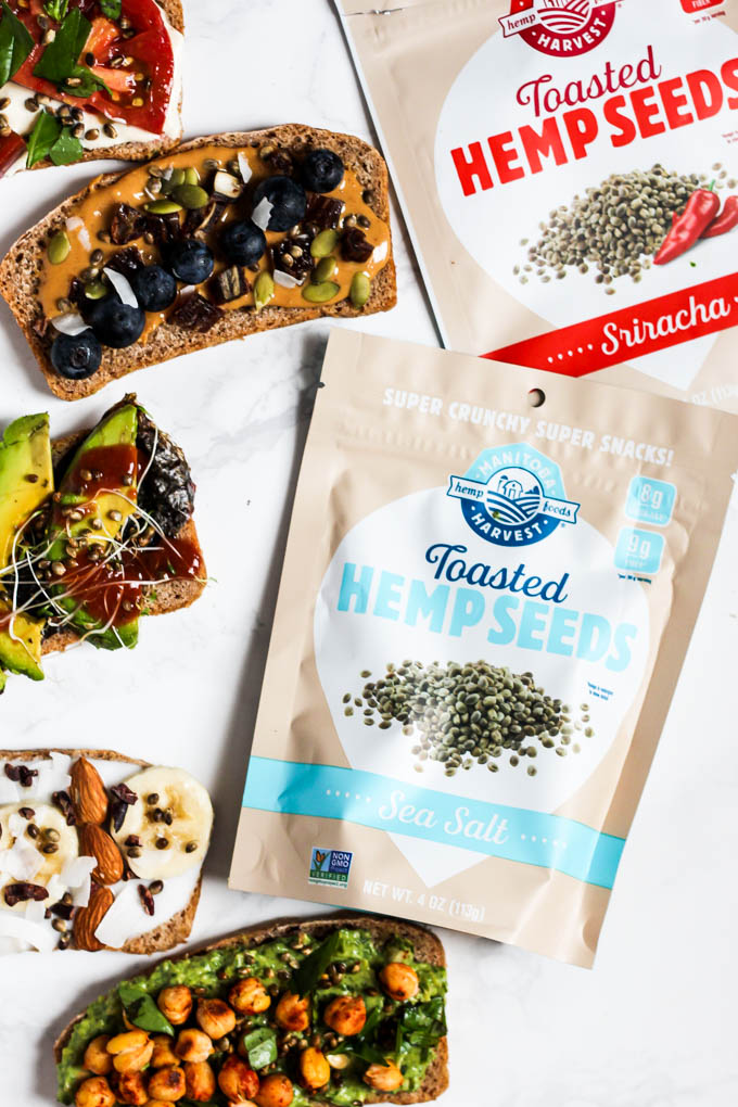 A collection of 5 different topped toasts alongside two bags of toasted hemp hearts
