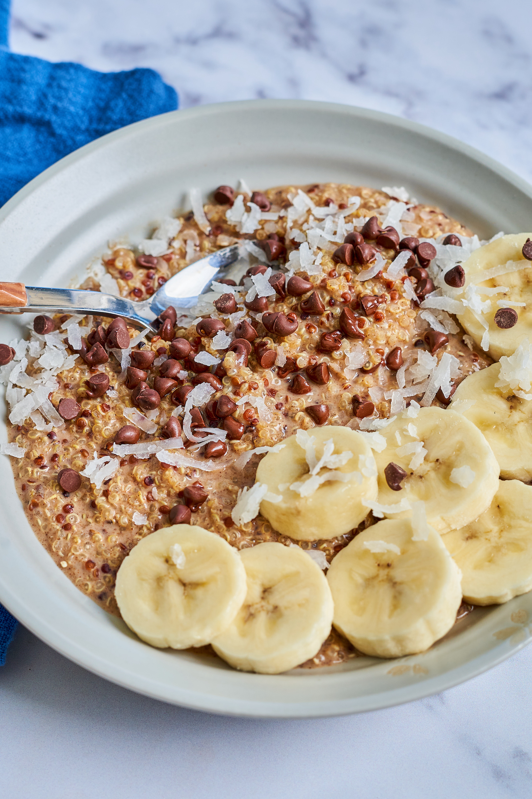 a closeup of a bowl of quinoa porridge topped with sliced banana