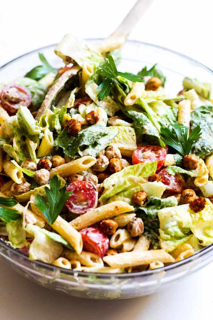 A large bowl of mixed caesar pasta salad