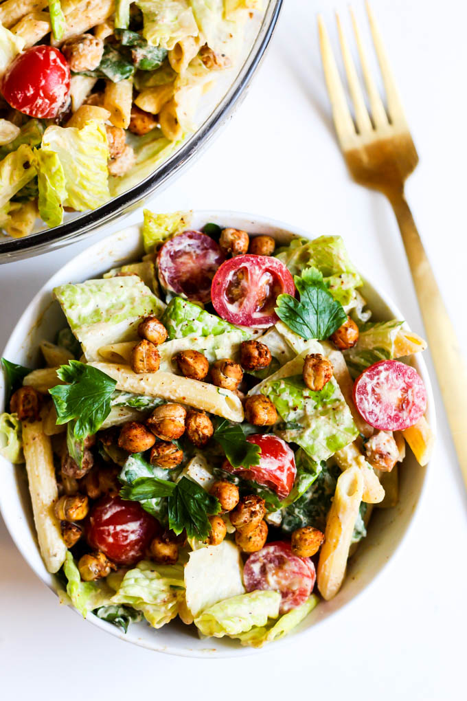 A single serving of plant-based caesar pasta salad topped off with roasted chickpeas