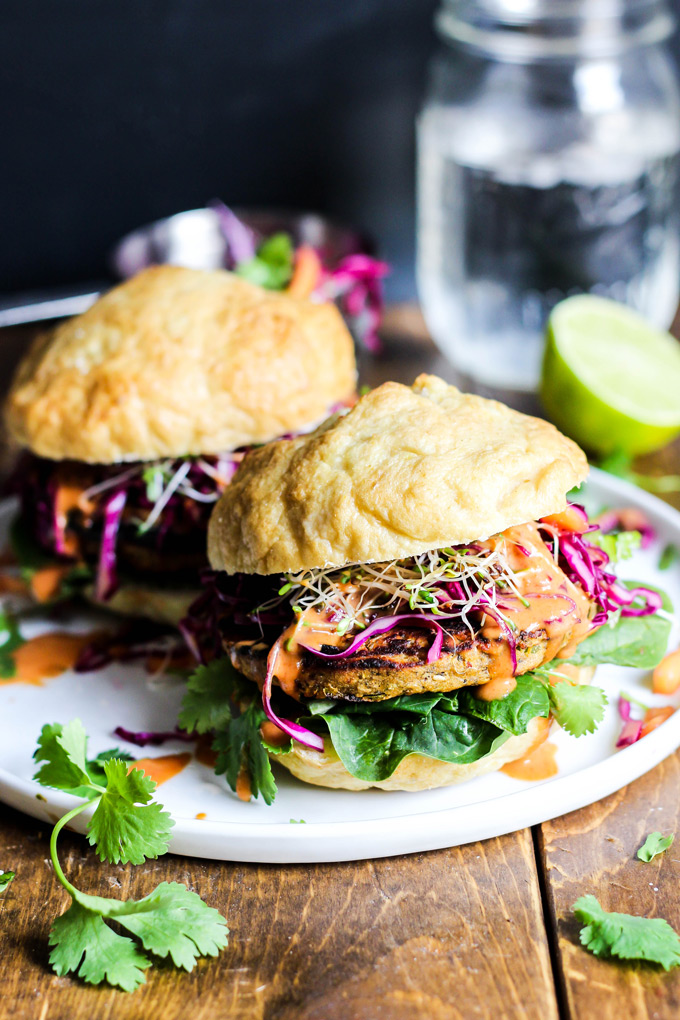 These vegan Asian Veggie Burgers are full of flavor & plant protein! Perfect for weekend grilling, topped with Mango Cabbage slaw and spicy Sriracha sauce.