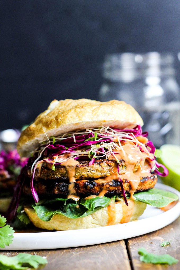 These vegan Asian Veggie Burgers are full of flavor & plant protein! Perfect for weekend grilling, topped with Mango Cabbage slaw and spicy Sriracha sauce.