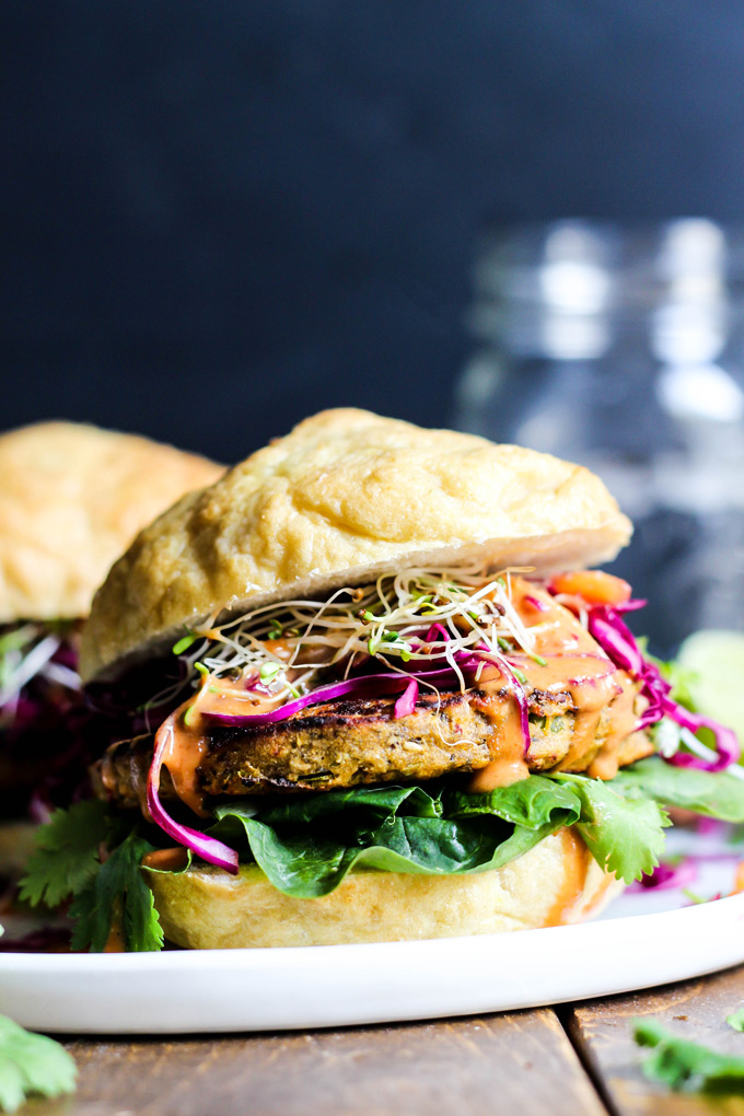 These vegan Asian Veggie Burgers are full of flavor & plant protein! Perfect for weekend grilling, topped with Mango Cabbage slaw and spicy Sriracha sauce.