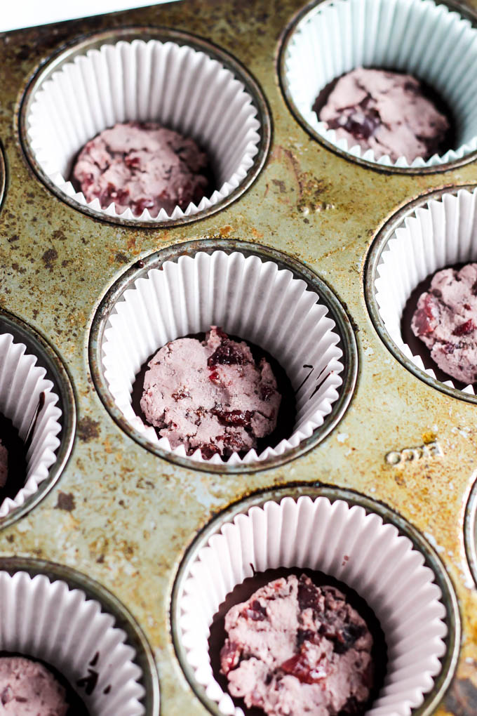 a muffin tray filled with a cherry coconut butter filling