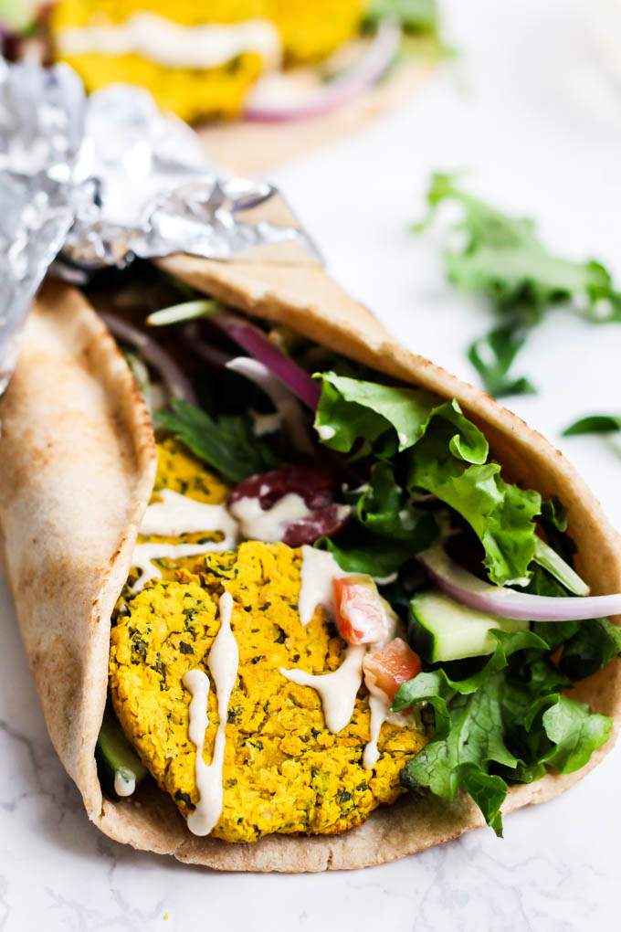 a falafel wrap with greens and a drizzle of tahini