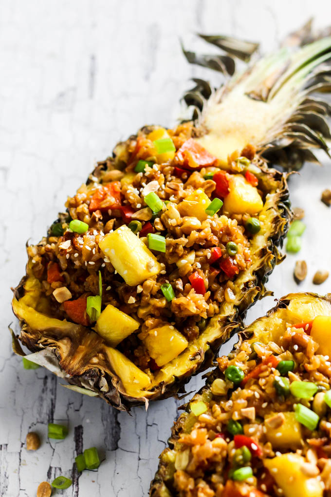 A hollowed out half of a pineapple is used as a dish to serve vegan fried rice