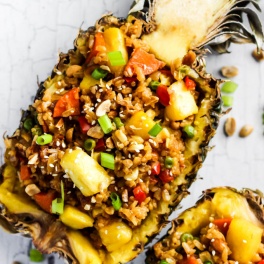 A hollow half of a pineapple serving fried rice