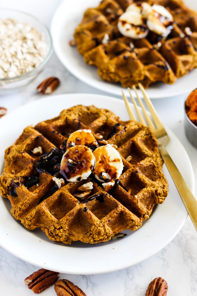 two waffles each topped with sliced bananas, chopped pecans and molasses