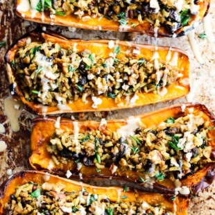 a tray of stuffed squash topped with tahini