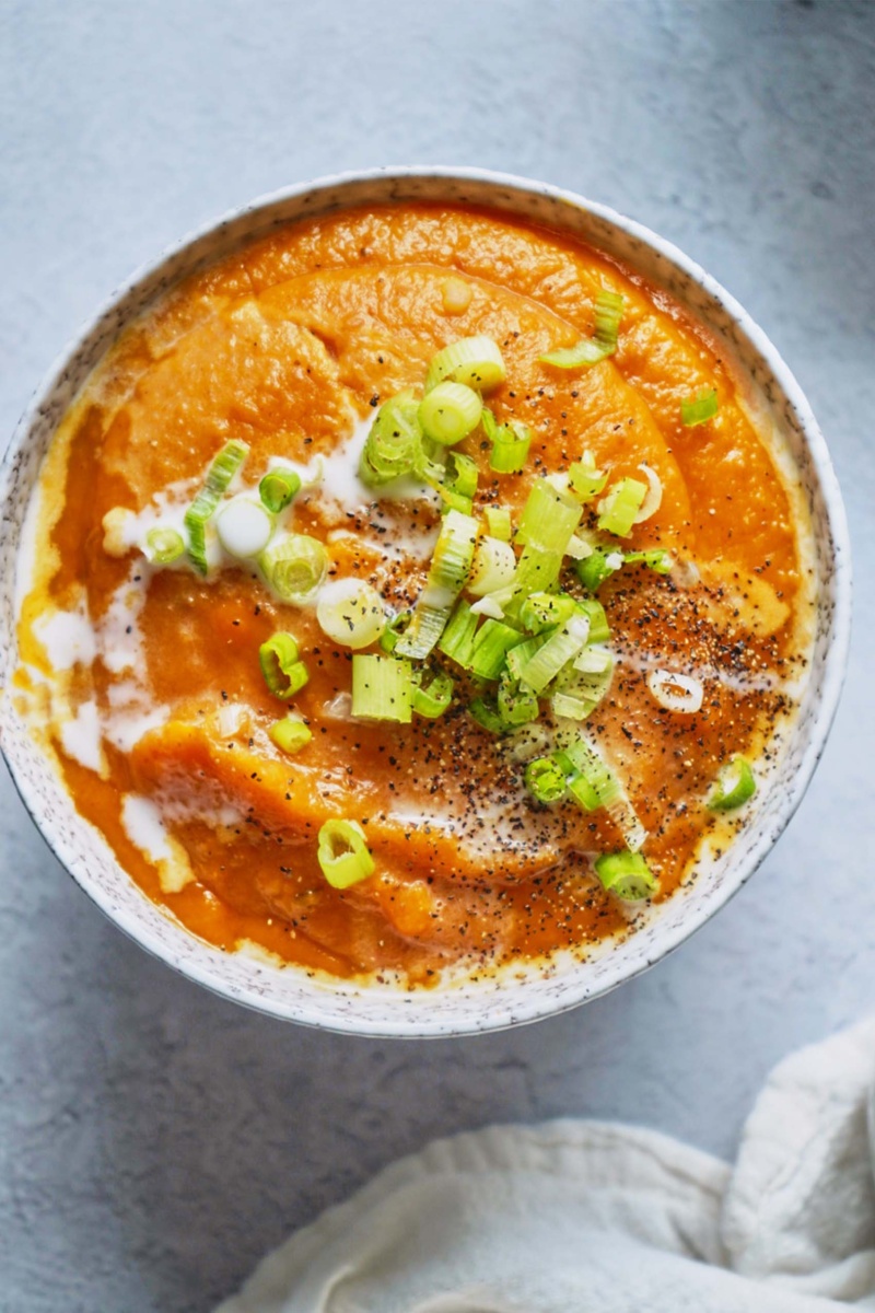 a bowl of sweet potato soup topped with green onion