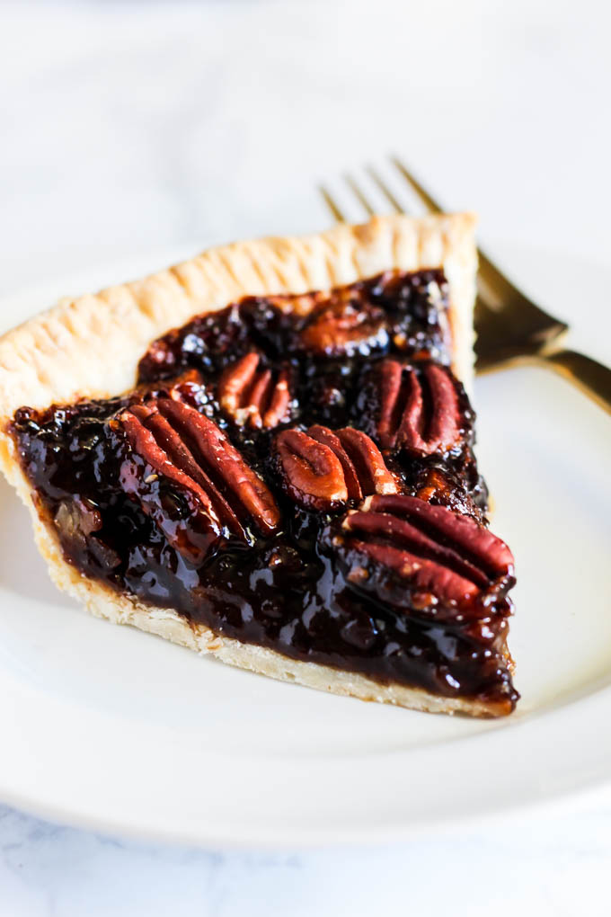 A slice of this Vegan Pecan Pie is all you need this holiday season! The sweet, gooey pecan filling tops a flaky crust that is irresistible. A must-have!