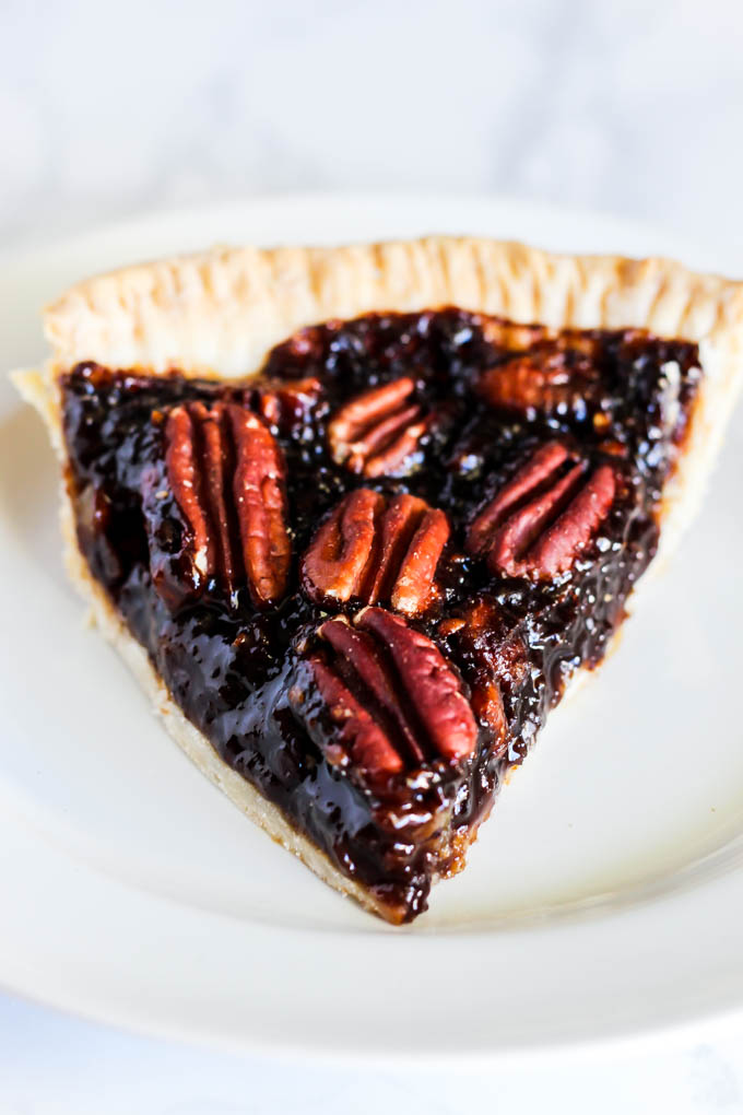 A slice of this Vegan Pecan Pie is all you need this holiday season! The sweet, gooey pecan filling tops a flaky crust that is irresistible. A must-have!