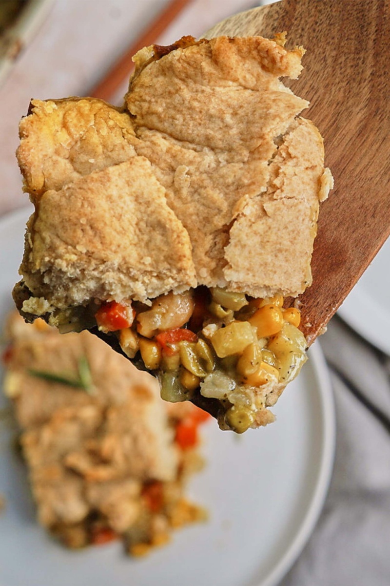 a scoop of chickpea pot pie on a wooden spoon