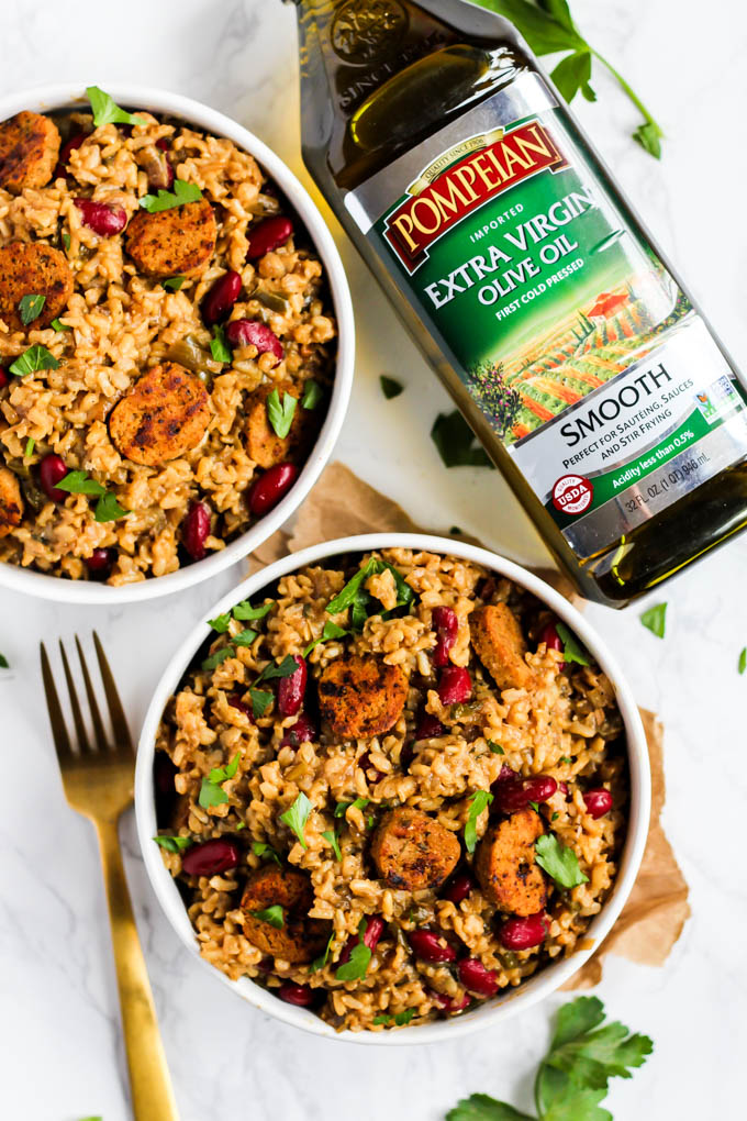 two bowls of jambalaya next to a bottle of olive oil