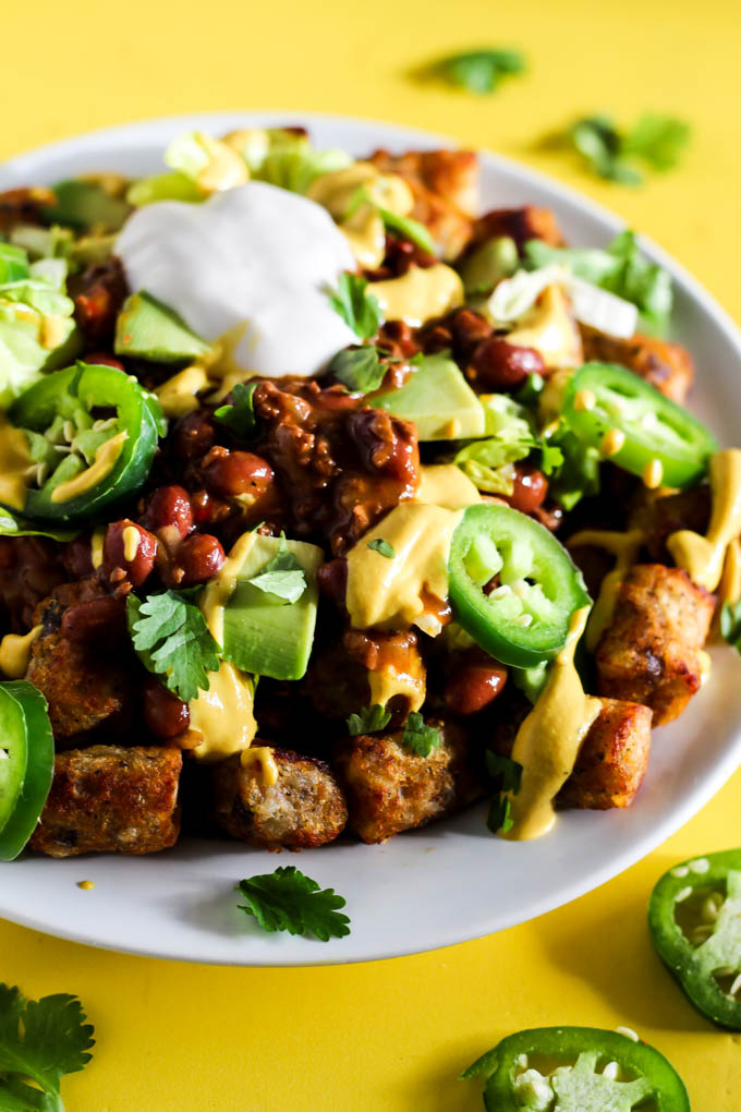 Serve up a plate of these Loaded Vegan Chili Cheese Tots as a delicious appetizer perfect for sharing! Full of bean chili, dairy-free cheese, and veggies.