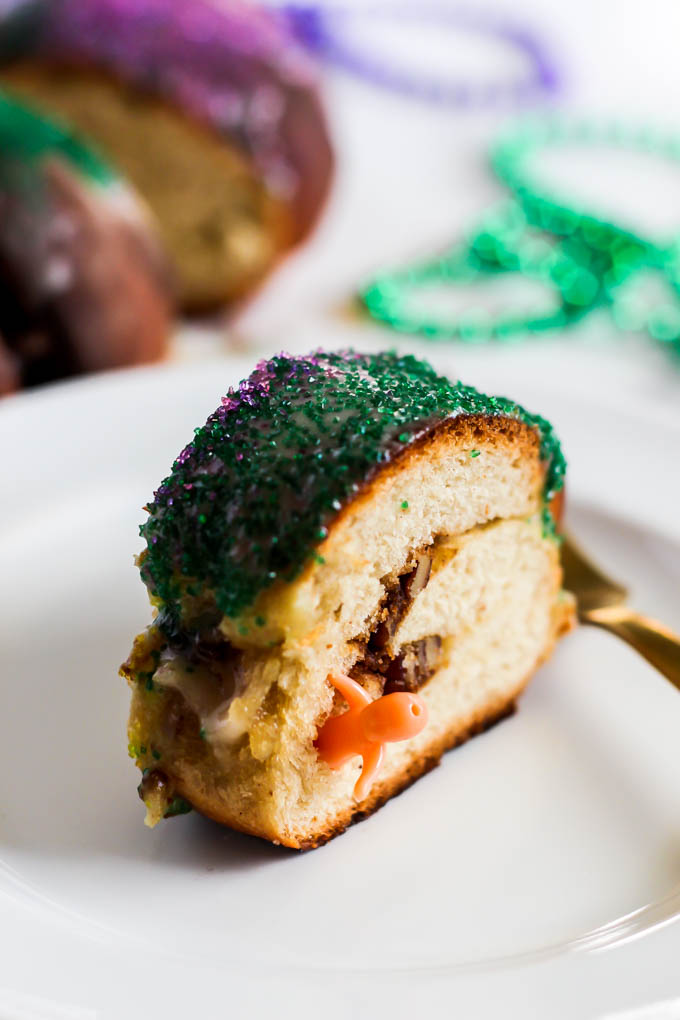 a slice of king cake holding a plastic baby