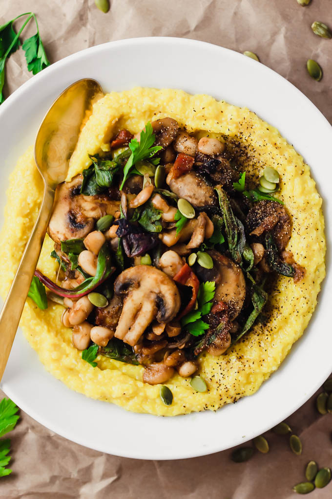 a bowl of vegan polenta topped with mushrooms and beans