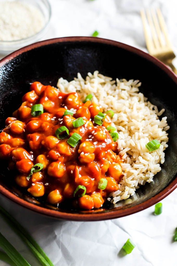 Chickpeas cooked in a sweet and sour sauce served on top of a scoop of brown rice and topped with chopped green onion