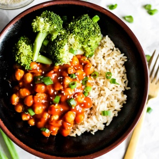 A bowl of broccoli and brown rice topped with sweet and sour chickpeas and green onion