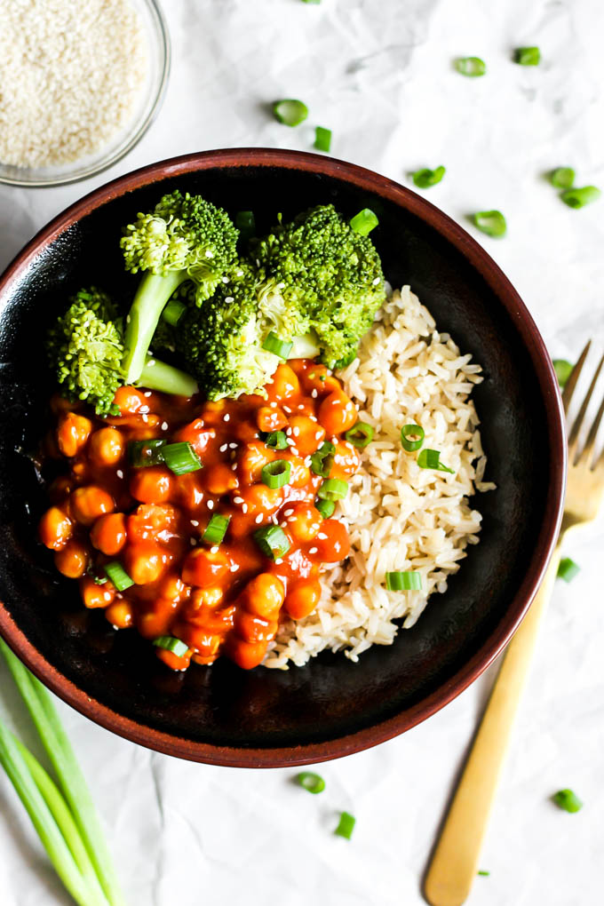 A bowl of broccoli and brown rice topped with sweet and sour chickpeas and green onion