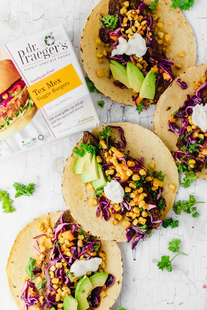 four vegan corn tacos filled with sliced avocado, vegan sour cream, and mango slaw served along side a box of veggie burgers