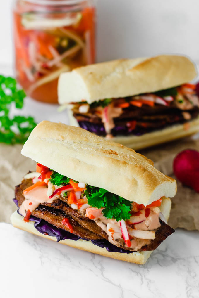 Layers of seitan are piled high with pickled vegetables and Sriracha mayo on a fluffy baguette in this Vegan Banh Mi! These satisfying sandwiches are great for packable lunches or to serve to a crowd.