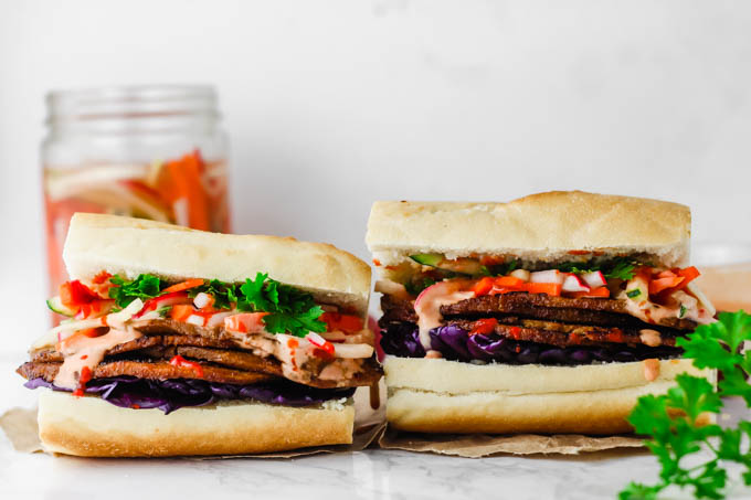 Layers of seitan are piled high with pickled vegetables and Sriracha mayo on a fluffy baguette in this Vegan Banh Mi! These satisfying sandwiches are great for packable lunches or to serve to a crowd.