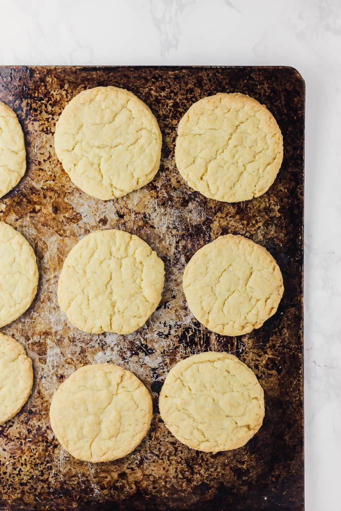 Vegan sugar cookies resting on a cookie sheet before being decorated