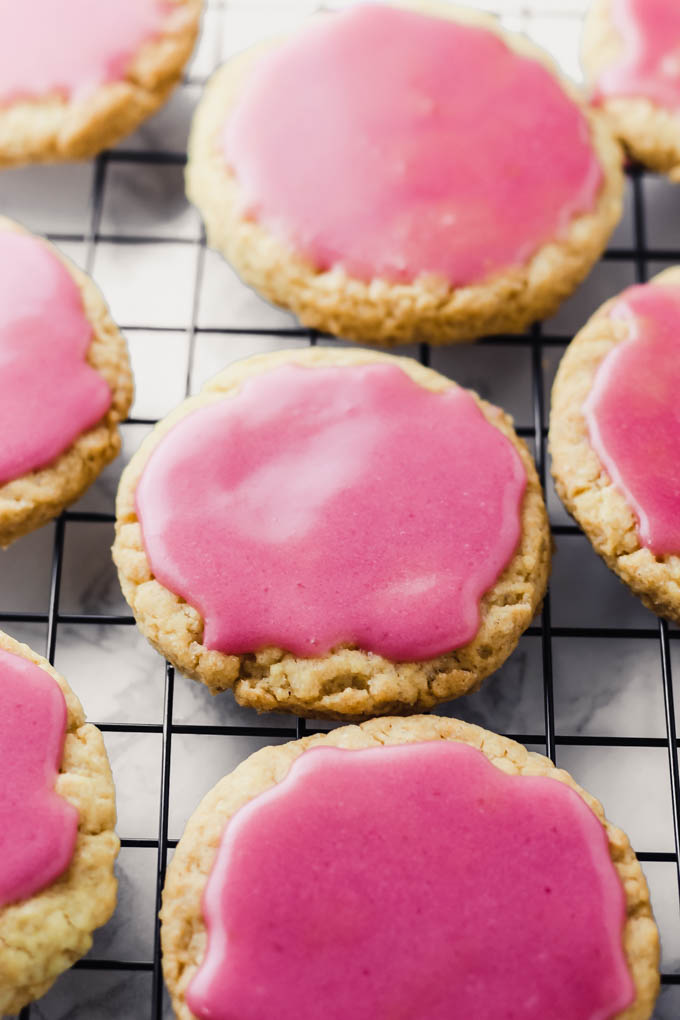 A collection of sugar cookies topped with a pink blood orange glaze