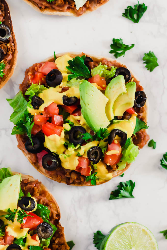 These Vegan Seven Layer Tostadas are loaded with all of your favorite taco toppings like beans, cashew cheese and avocado! A healthy 30-minute meal great for busy weeknights or for serving a crowd.