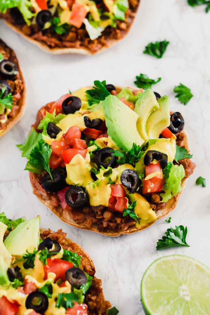 These Vegan Seven Layer Tostadas are loaded with all of your favorite taco toppings like beans, cashew cheese and avocado! A healthy 30-minute meal great for busy weeknights or for serving a crowd.