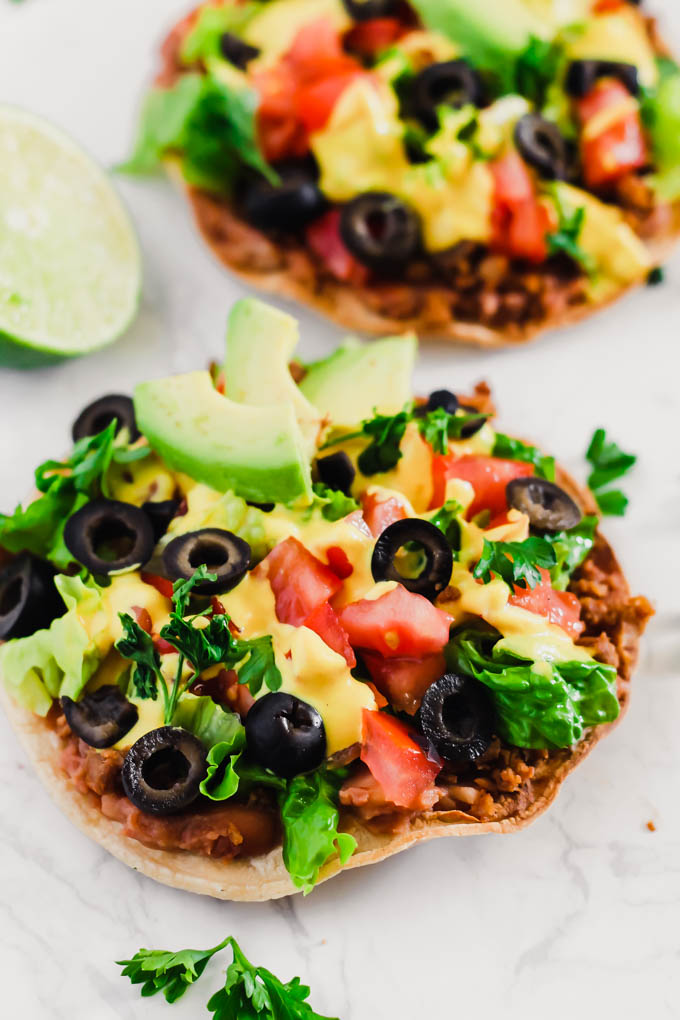 These Vegan Seven Layer Tostadas are loaded with all of your favorite taco toppings like beans, cashew cheese and avocado! A healthy 30-minute meal great for busy weeknights or for serving a crowd.