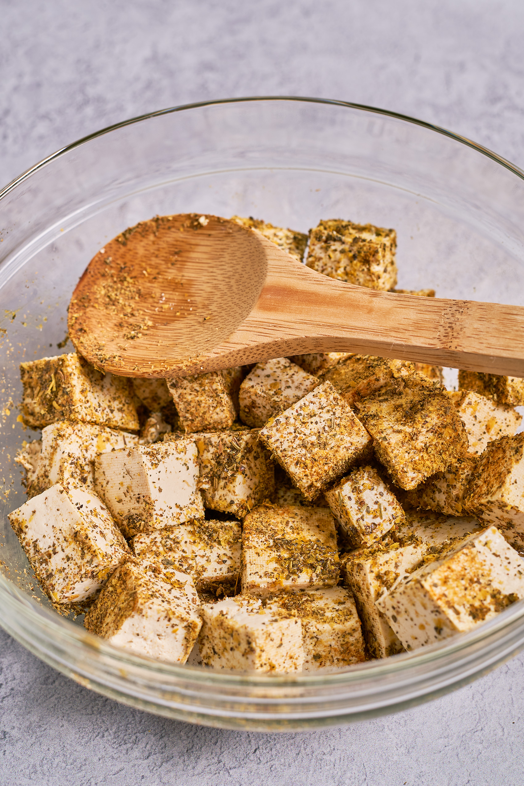 a bowl of cubed tofu in a mixing bowl with spices