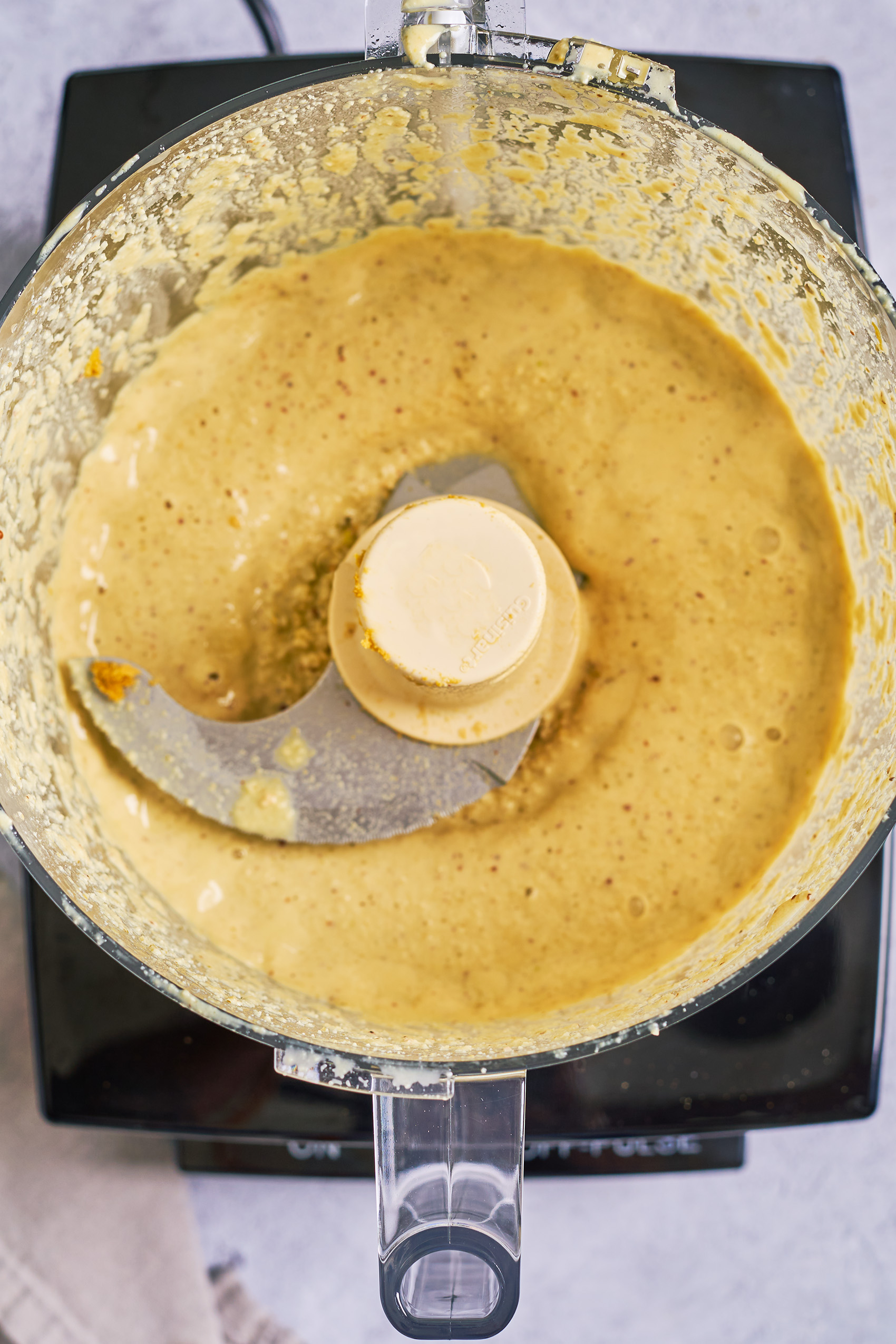 a food processor bowl of vegan caesar dressing