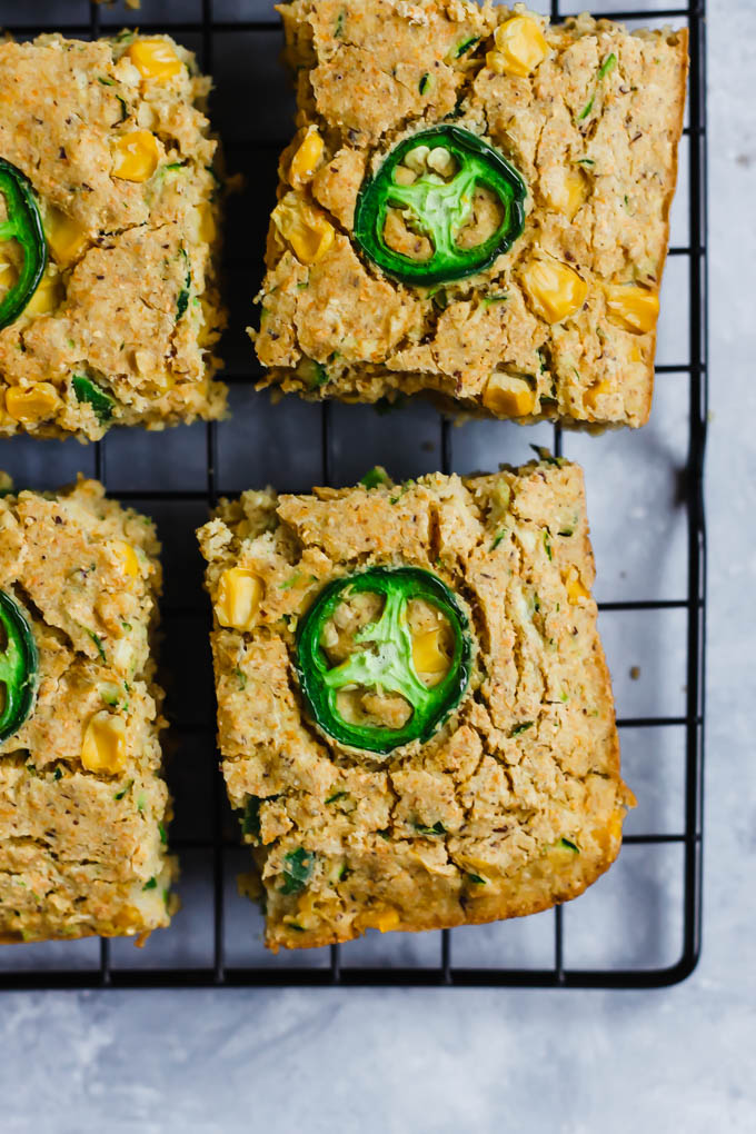 squares of cornbread each topped with a slice of jalapeno